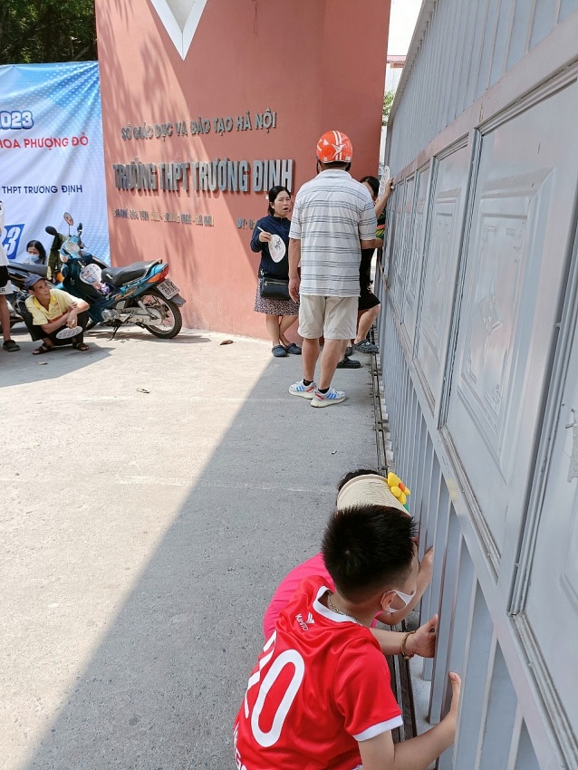 Các em nhỏ cũng đang hướng vào phòng thi tại điểm thi trường THPT Trương Định nơi anh mình làm bài.