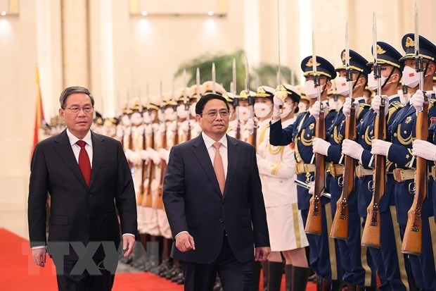 Thủ tướng Phạm Minh Chính và Thủ tướng Trung Quốc Lý Cường duyệt đội danh dự. (Ảnh: Dương Giang/TTXVN)