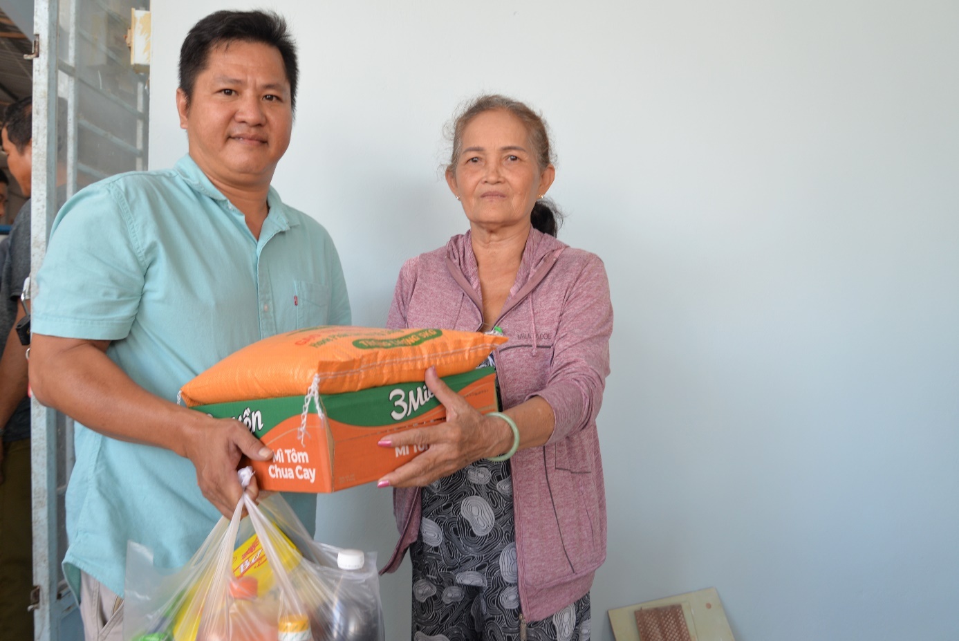 Anh Minh Tuấn, đại diện Tạp chí Sức khỏe và Môi trường trao quà cho người dân