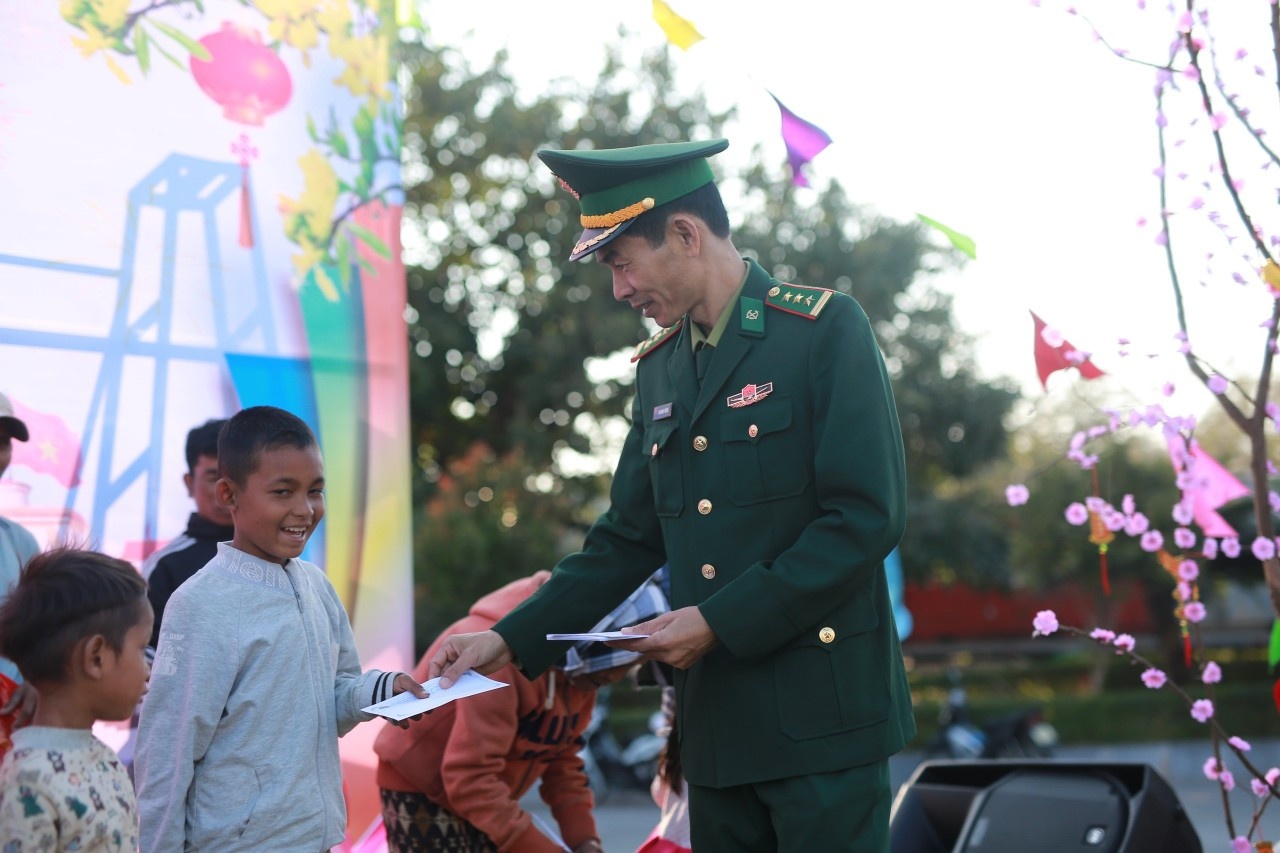 Thượng tá Phan Mạnh Trường - Bí thư Đảng ủy, Chính trị viên Đồn Biên phòng Cửa khẩu Quốc tế Lao Bảo, tặng quà trẻ em ở bản Đensavan, huyện Sê Pôn, tỉnh Savannakhet