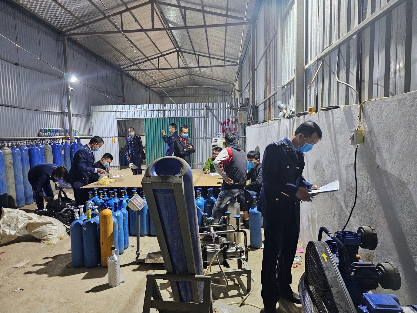 Phát hiện cơ sở san chiết khí N2O ẩn trong khu nhà lợp mái tôn tại huyện Hoài Đức, Hà Nội. Ảnh CQLTTHN Phát hiện cơ sở san chiết khí N2O ẩn trong khu nhà lợp mái tôn tại huyện Hoài Đức, Hà Nội. Ảnh CQLTTHN