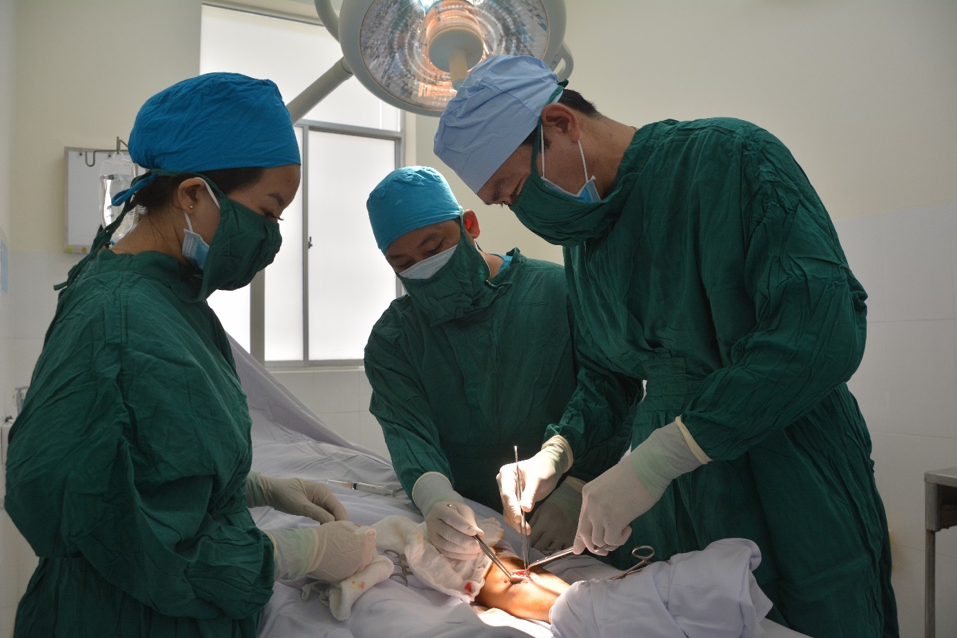 Thượng tá, Bác sĩ CKII Nguyễn Minh Phong (bên phải) cùng ê kíp tiến hành mổ cấp cứu cho bệnh nhân.