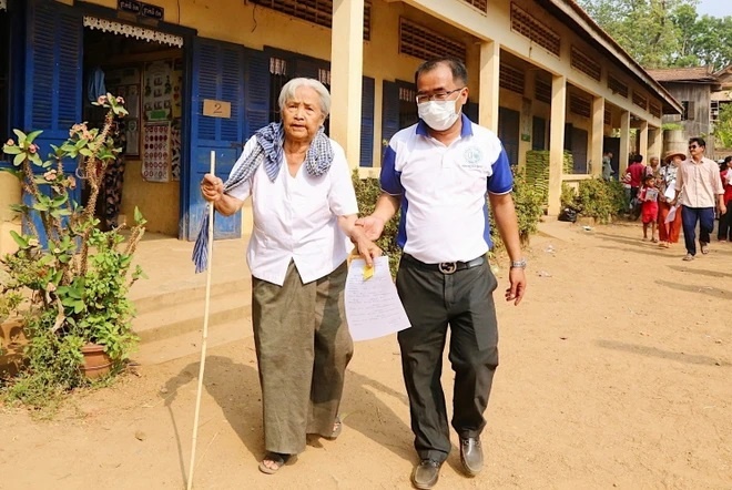 Thành viên ban tổ chức hỗ trợ người cao tuổi đến thăm khám. (Ảnh: Quang Anh/TTXVN)