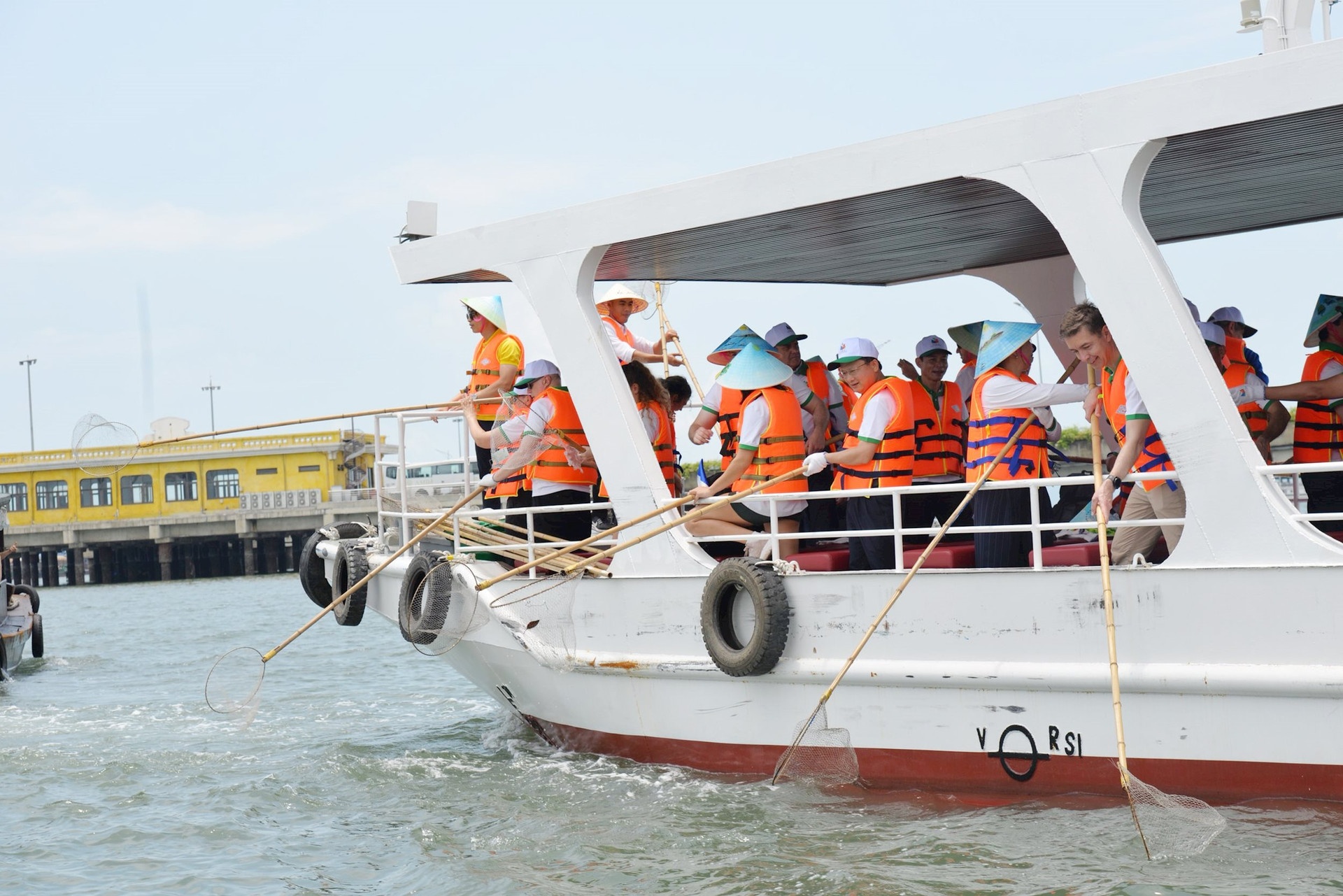 Các đại biểu thu gom rác trên biển tại khu Cảng tàu khách quốc tế Hạ Long