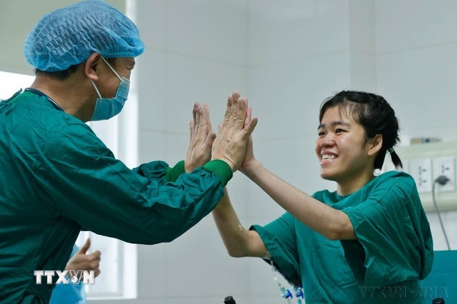 Niềm vui của bác sỹ và bệnh nhân P.A.T (phải) khi sức khỏe tiến triển tốt, hồi phục nhanh sau ca ghép phổi. Sự thành công của ca ghép phổi là thành tựu tiêu biểu của ngành y tế Việt Nam, góp phần mang lại những giá trị to lớn cho sức khỏe người bệnh và nhân dân. (Ảnh: TTXVN)