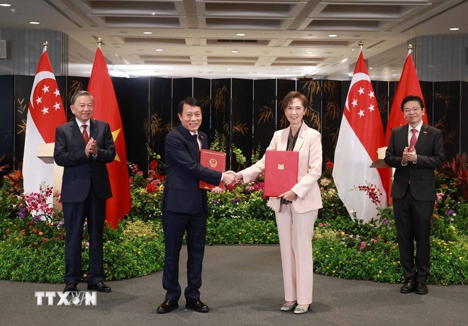 Tổng Bí thư Tô Lâm và Thủ tướng Singapore Lawrence Wong chứng kiến trao Thỏa thuận hợp tác về phòng ngừa và đấu tranh chống tội phạm xuyên quốc gia giữa Bộ Công an Việt Nam và Bộ Nội vụ Singapore. (Ảnh: TTXVN)