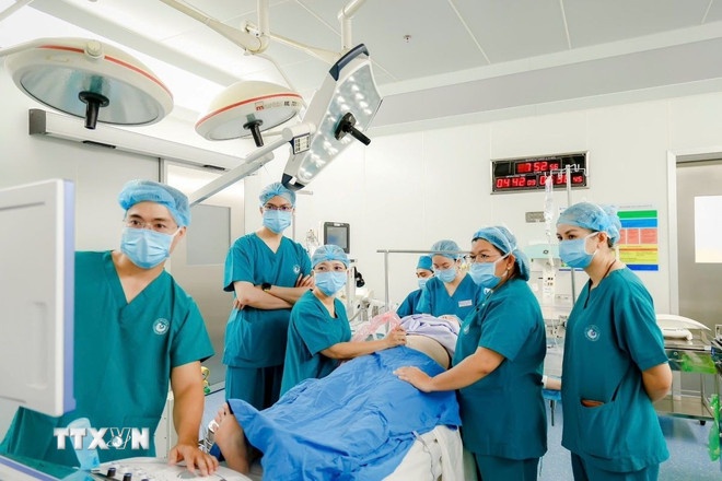 Các bác sỹ 2 bệnh viện Từ Dũ và Nhi Đồng 1 phối hợp phẫu thuật cho sản phụ người Singapore. (Ảnh: TTXVN) Các bác sỹ 2 bệnh viện Từ Dũ và Nhi Đồng 1 phối hợp phẫu thuật cho sản phụ người Singapore. (Ảnh: TTXVN)