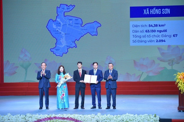  Bí thư Thành ủy Hà Nội Bùi Thị Minh Hoài và Phó Bí thư Thường trực Thành ủy Hà Nội Nguyễn Văn Phong trao quyết định và tặng hoa cho lãnh đạo các phường, xã mới. Ảnh: VGP