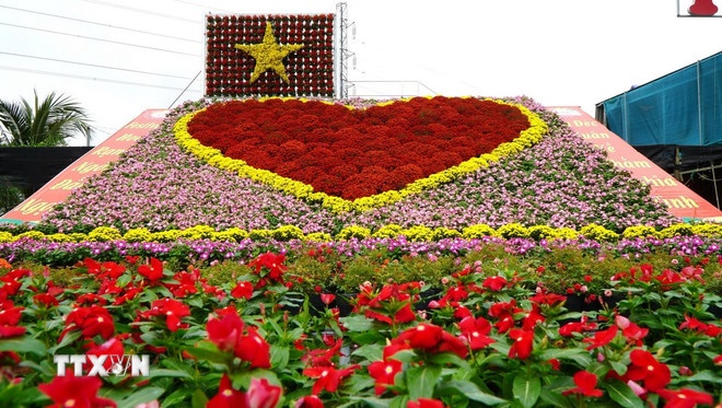Tiểu cảnh “Trái tim” kết hợp cùng cờ đỏ, sao vàng được xếp hình từ khoảng 1.700 chậu hoa tươi các loại ở Làng hoa Sa Đéc (Đồng Tháp). (Ảnh: TTXVN)