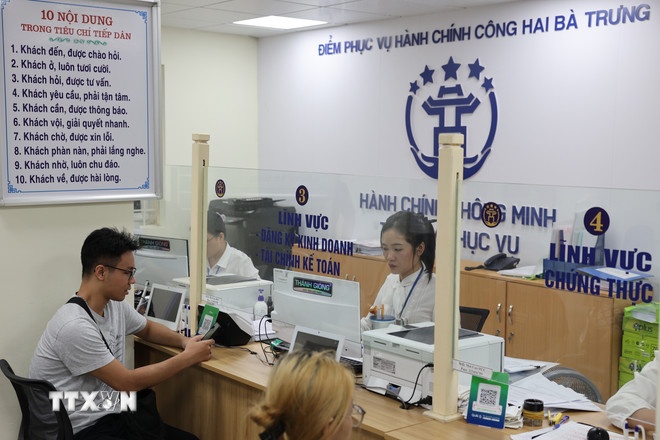   Người dân được cán bộ, công chức hỗ trợ giải quyết hồ sơ tại Điểm phục vụ Hành chính công phường Hai Bà Trưng (Hà Nội). (Ảnh: TTXVN)