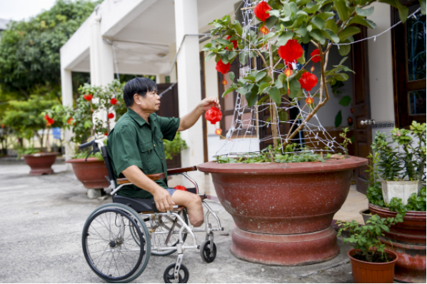 Bác Nguyễn Công Thắng – cựu chiến binh đang được chăm sóc tại Trung tâm Điều dưỡng Thương binh và Người có công Long Đất – chăm chút cho góc Tết trước phòng ở (Ảnh: Minh Anh).