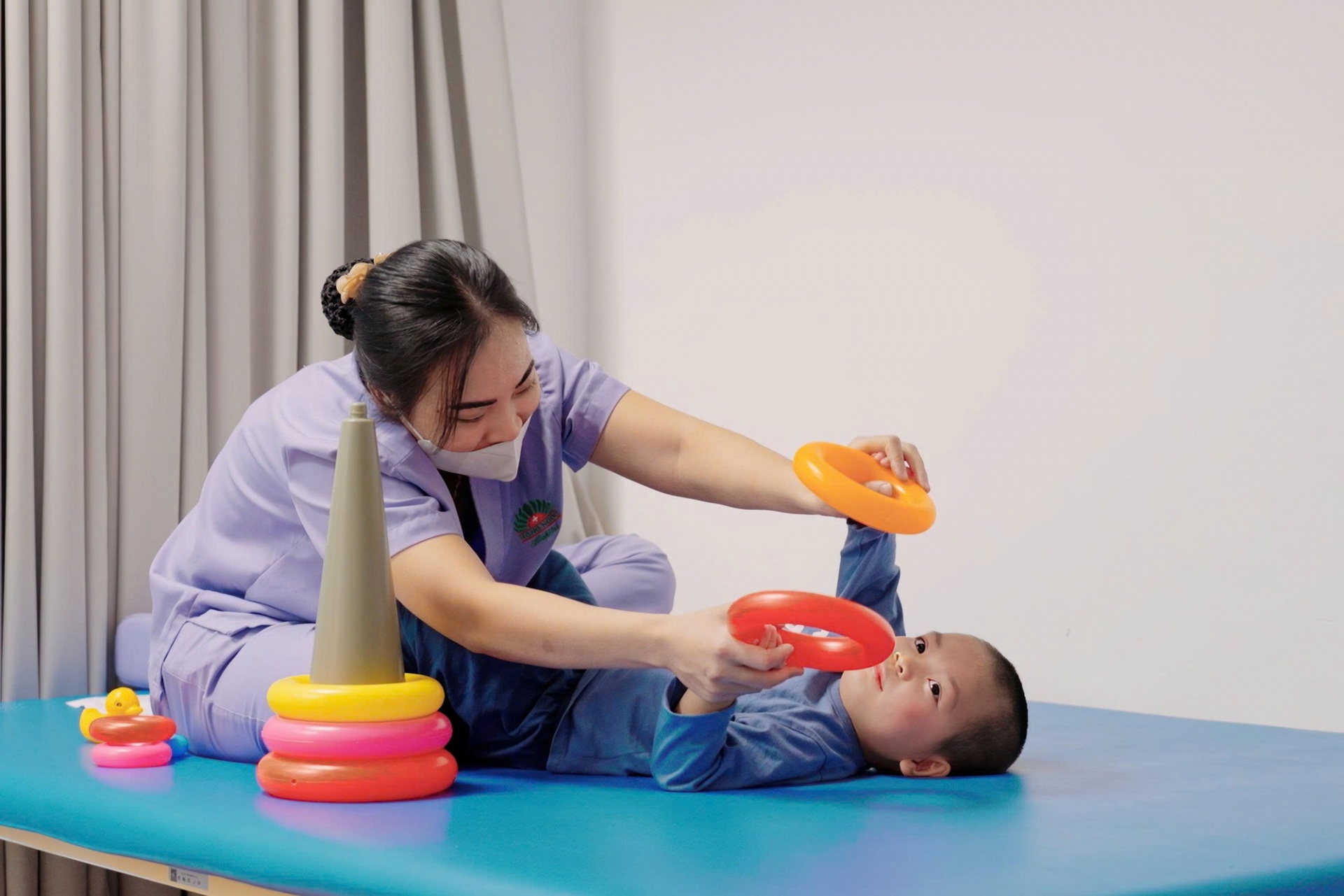 Trẻ đang tập vật lý trị liệu cùng kỹ thuật viên Trẻ đang tập vật lý trị liệu cùng kỹ thuật viên