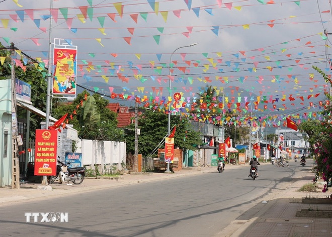 Các tuyến đường về xã Diên Điền, vùng rốn lũ lịch sử 11/2025, được trang hoàng rực rỡ cờ hòa. (Ảnh: TTXVN)