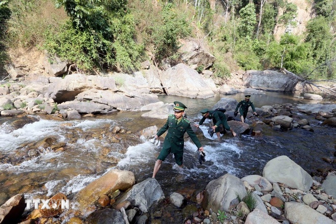 Cán bộ Đồn Biên phòng Mường Lèo (Ban Chỉ huy Bộ đội Biên phòng tỉnh Sơn La) vượt qua các con suối đến từng nhà, từng bản để tuyên truyền về bầu cử đến với đồng bào các dân tộc. (Ảnh: TTXVN)