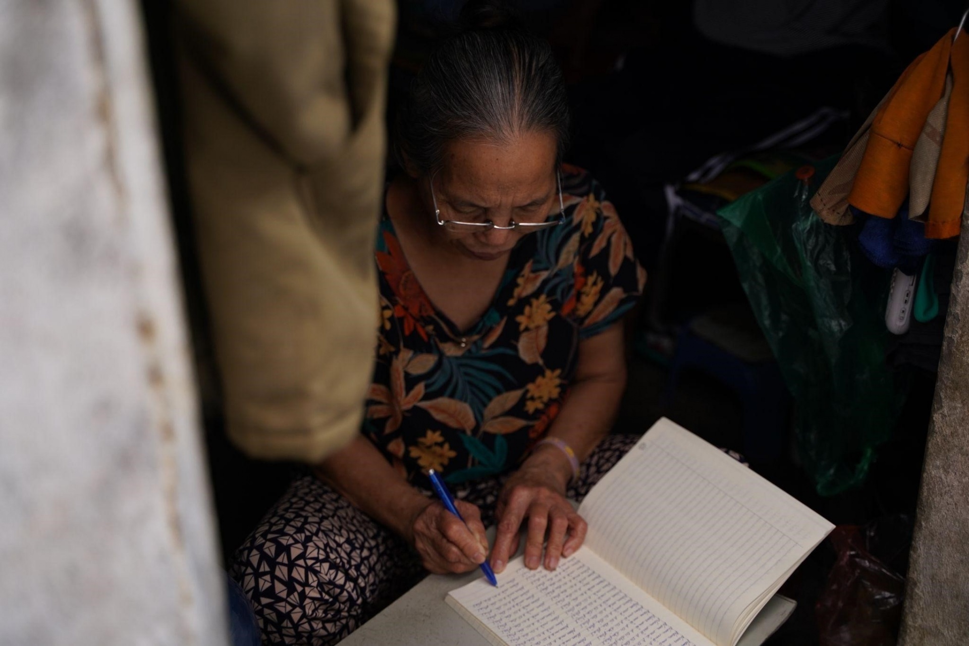 Bà Tư chép Kinh Phật kiếm tiền trang trải cuộc sống trong căn phòng nhỏ (Ảnh: Phùng Dung) Bà Tư chép Kinh Phật kiếm tiền trang trải cuộc sống trong căn phòng nhỏ (Ảnh: Phùng Dung)