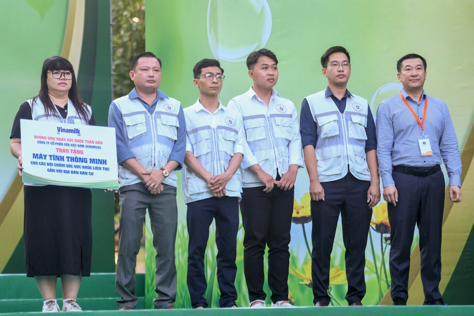 Đại diện Vinamilk, ông Đỗ Thanh Tuấn – Giám đốc Đối ngoại (ngoài cùng bên phải) trao tặng bảng tượng trưng máy tính thông minh đến đại diện các “Đội chăm sóc sức khỏe liên tục gắn với địa bàn dân cư” (Ảnh: VN).