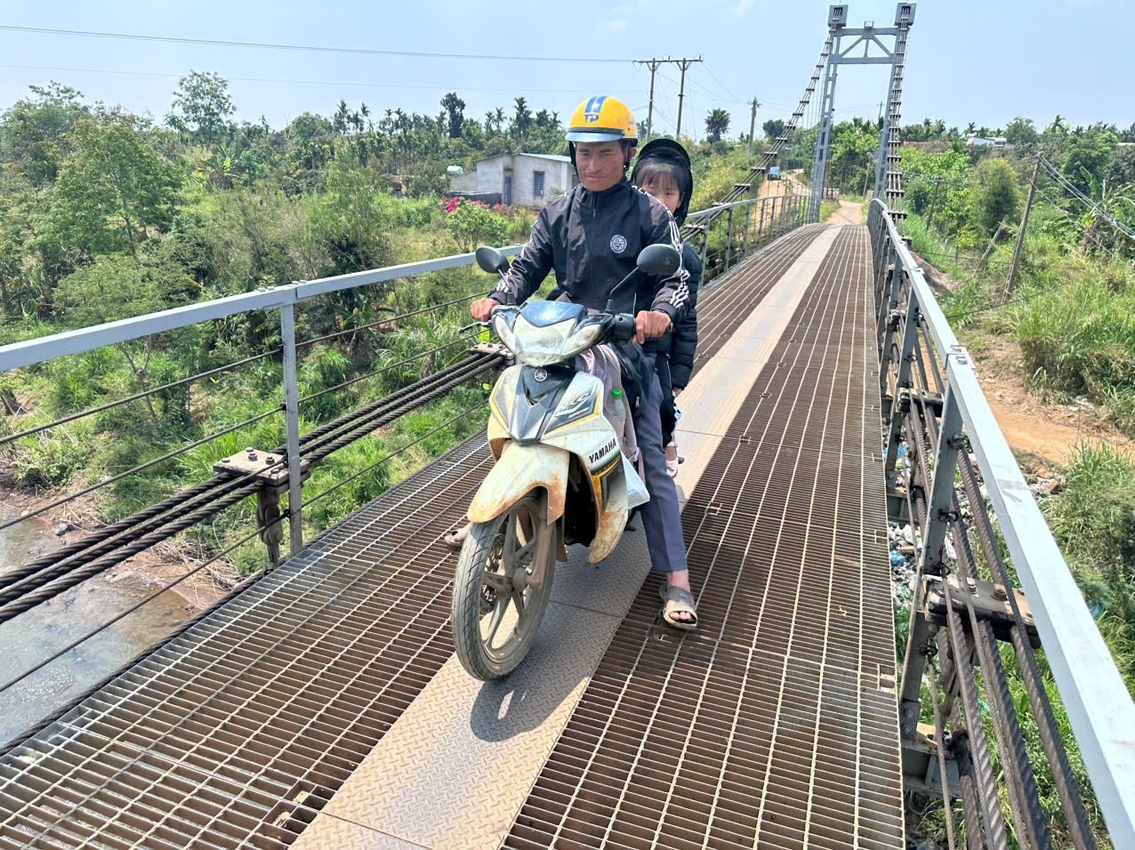  Hàng ngày, bố chở em Nguyễn Ngọc Bảo Châu vượt cầu treo, băng đường đá đến trường dù em đang mang bệnh hiểm nghèo.