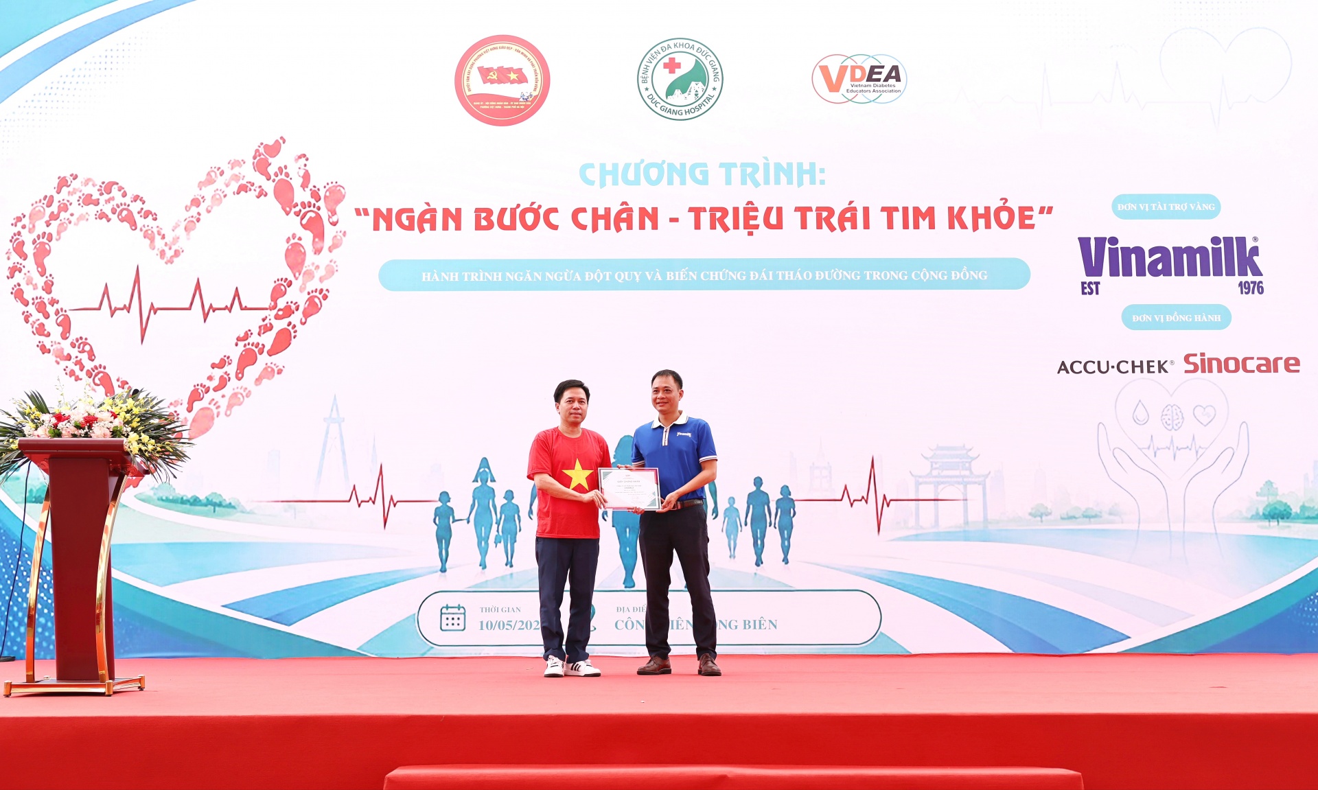 Ông Vũ Tuấn Khang (áo xanh) - Giám đốc Kinh doanh Hà Nội, Công ty Cổ phần sữa Việt Nam (Vinamilk) – nhận chứng nhận tài trợ từ Ban tổ chức chương trình “Ngàn bước chân – Triệu trái tim khỏe” (Ảnh: VN). Ông Vũ Tuấn Khang (áo xanh) - Giám đốc Kinh doanh Hà Nội, Công ty Cổ phần sữa Việt Nam (Vinamilk) – nhận chứng nhận tài trợ từ Ban tổ chức chương trình “Ngàn bước chân – Triệu trái tim khỏe” (Ảnh: VN).