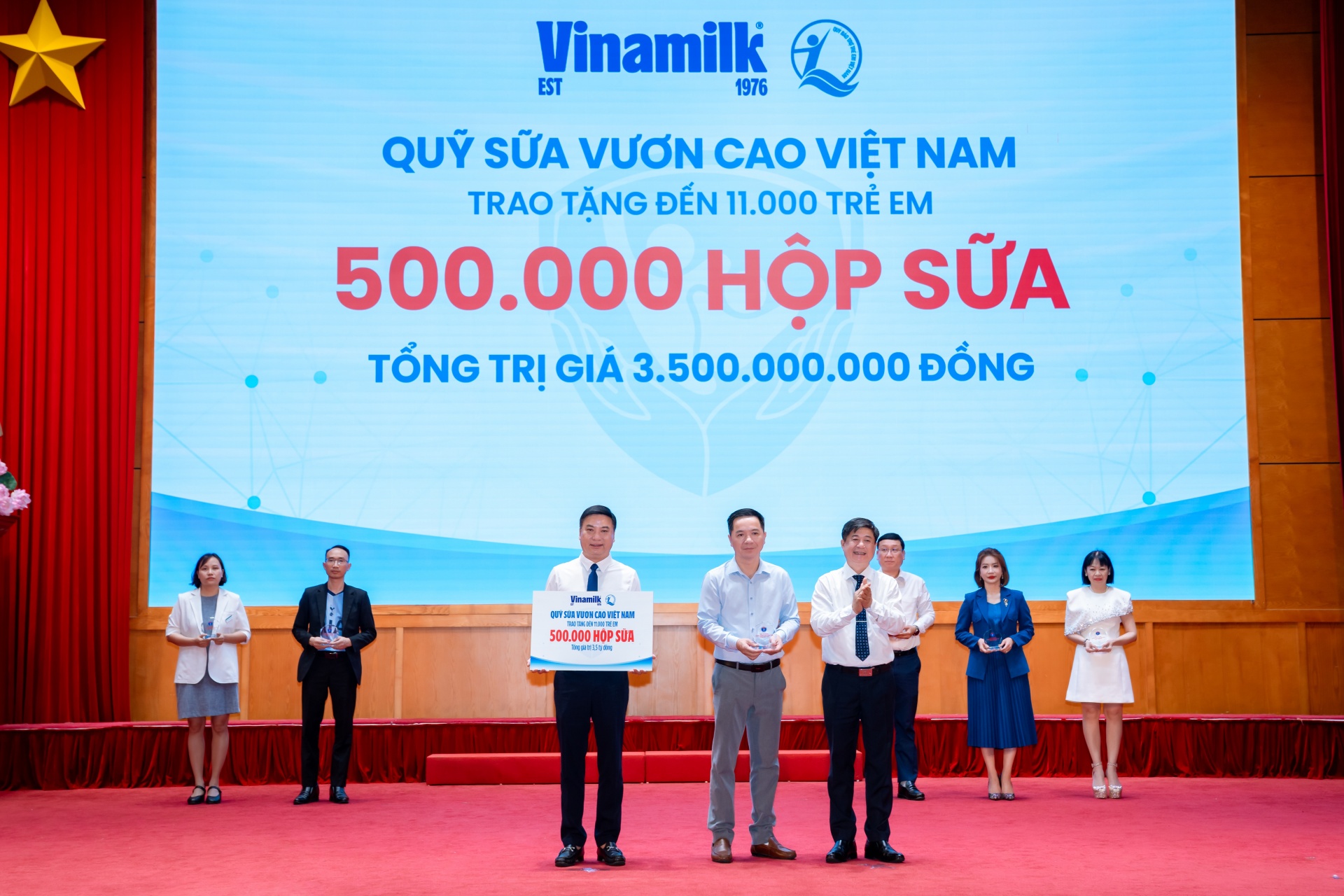 Đại diện Vinamilk (đứng giữa) trao bảng tượng trưng 500.000 hộp sữa và nhận kỷ niệm chương từ Bộ Y tế (Ảnh: VN). Đại diện Vinamilk (đứng giữa) trao bảng tượng trưng 500.000 hộp sữa và nhận kỷ niệm chương từ Bộ Y tế (Ảnh: VN).