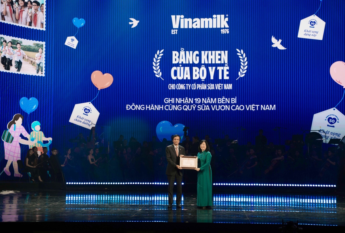 Đại diện Vinamilk, ông Nguyễn Hạnh Phúc – nguyên Uỷ viên Trung ương Đảng, Nguyên Tổng thư ký Quốc hội, Chủ tịch Hội đồng Quản trị - đón nhận Bằng khen của Ủy viên Trung ương Đảng, Bộ trưởng Bộ Y tế Đào Hồng Lan vì đã có nhiều thành tích đóng góp cho trẻ em thông qua Quỹ sữa Vươn cao Việt Nam (Ảnh: Minh Anh).