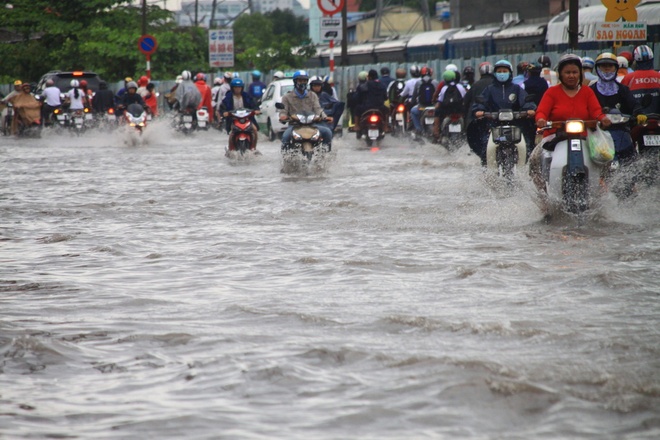 Sáng sớm người Sài Gòn đội mưa, lội nước đi làm