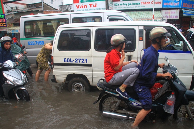 Sáng sớm người Sài Gòn đội mưa, lội nước đi làm