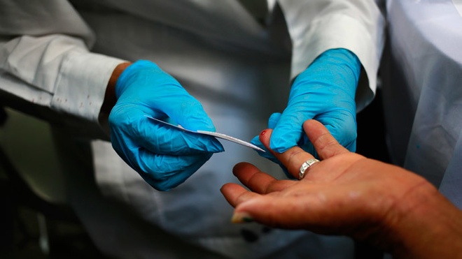 Nh&amp;amp;acirc;n vi&amp;amp;ecirc;n y tế lấy mẫu m&amp;amp;aacute;u của một người nghi nhiễm Ebola